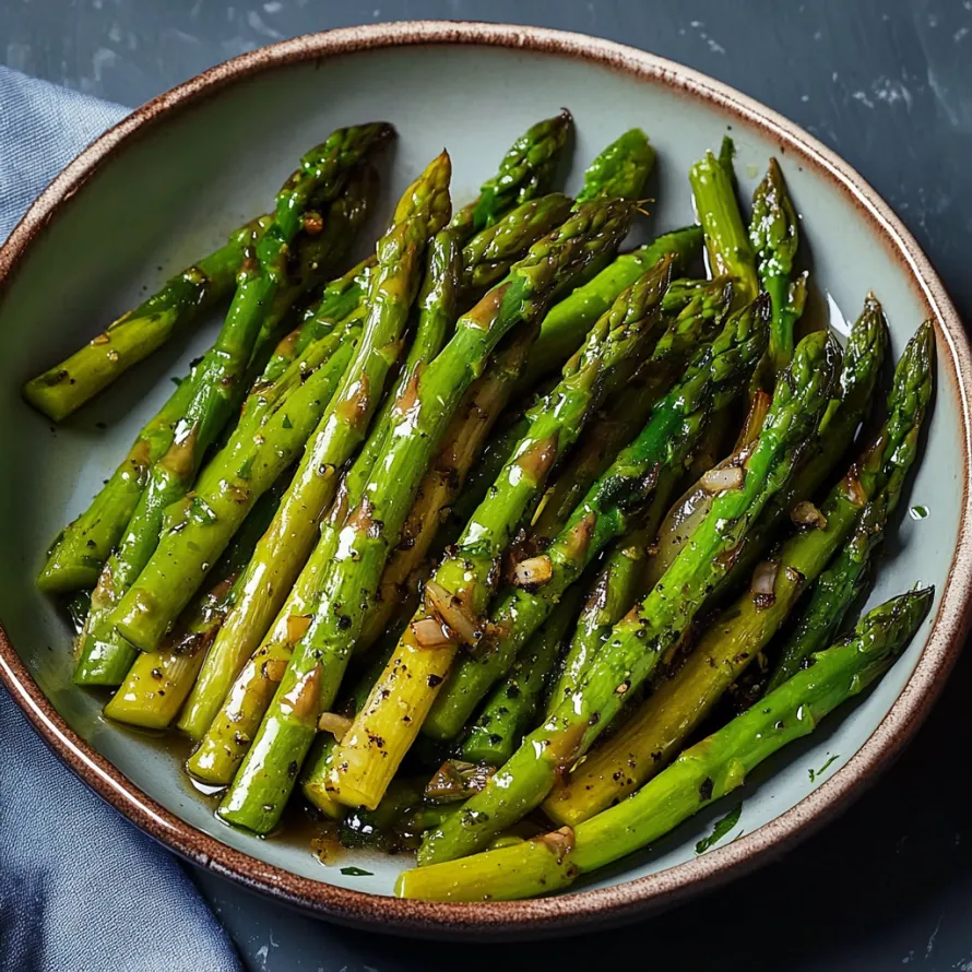 A bowl of asparagus with sauce.