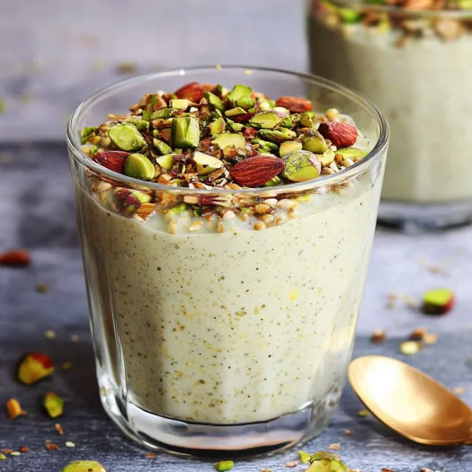 A glass of yogurt with nuts and seeds.