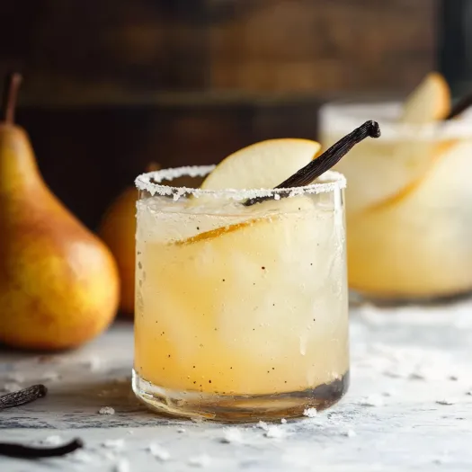 A glass of apple cider with a cinnamon stick in it.