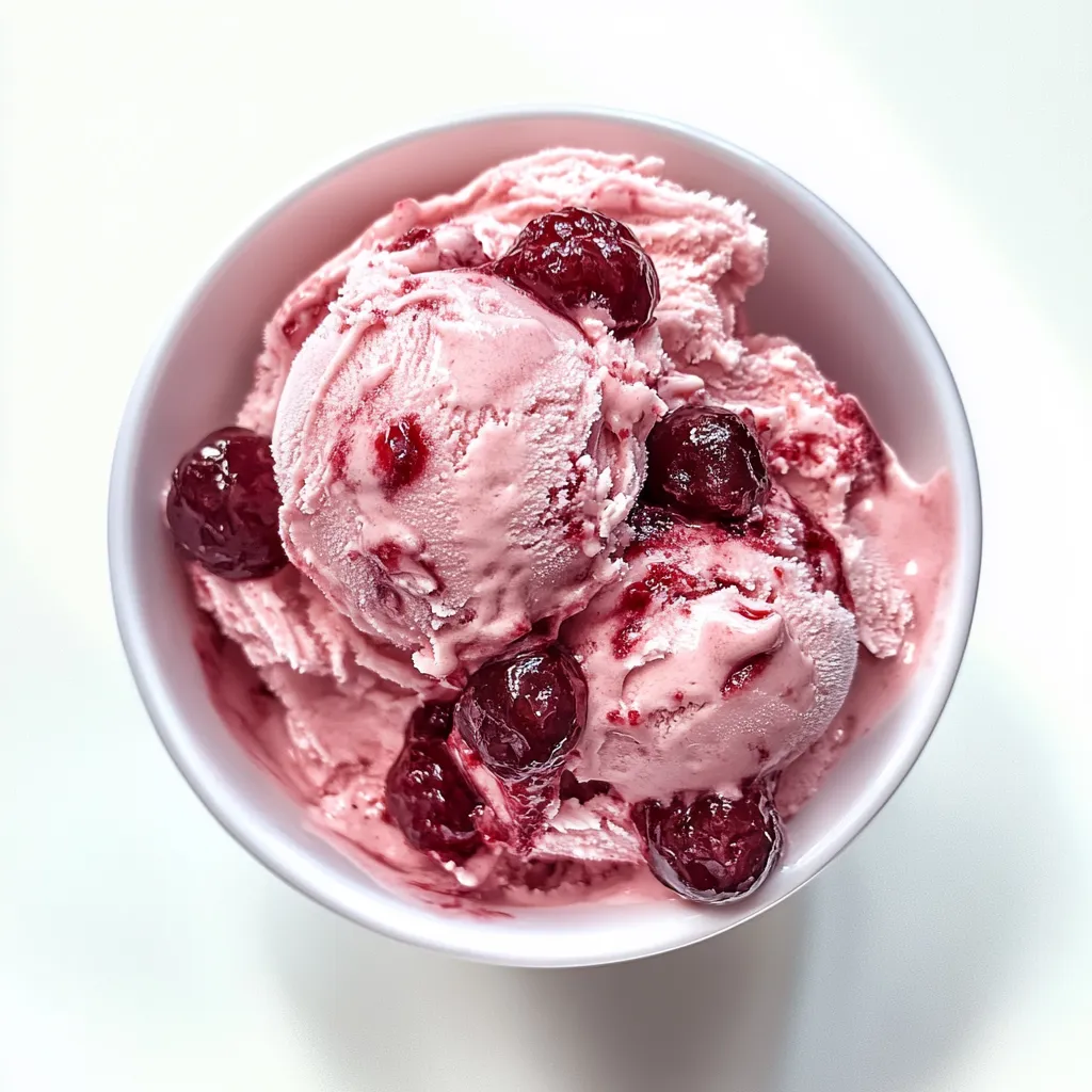 A bowl of pink ice cream with cherries on top.