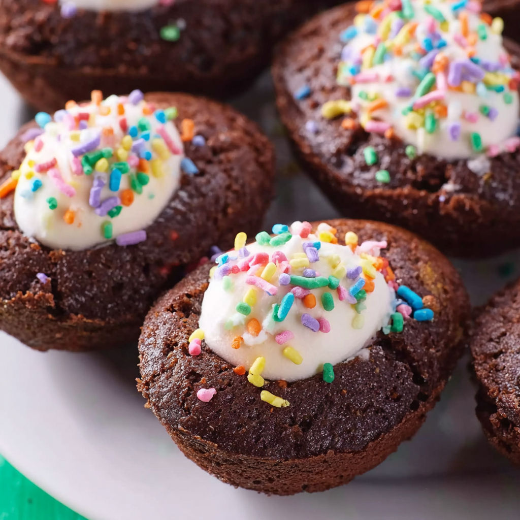 A plate of brownies with white frosting.