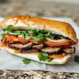 A sandwich with meat, tomatoes, onions, and lettuce.