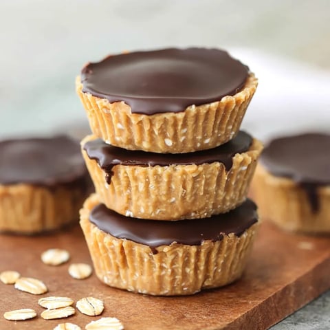 Stacked peanut oat chocolate cups on a rustic table.