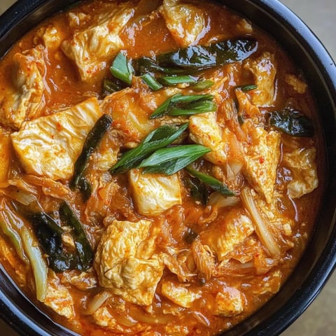 A spicy stew garnished with fresh greens in a bowl.