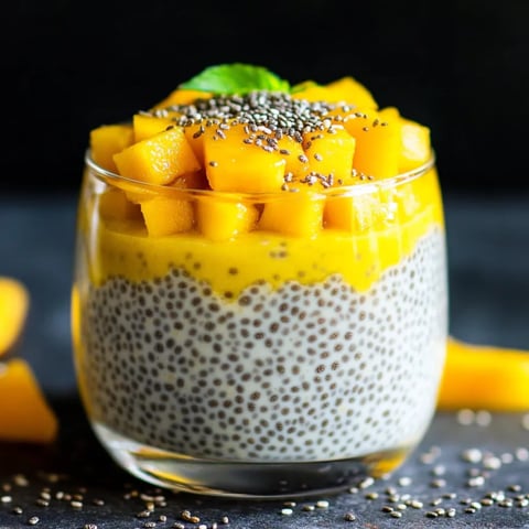 A glass of yogurt with chia seeds and fruit.