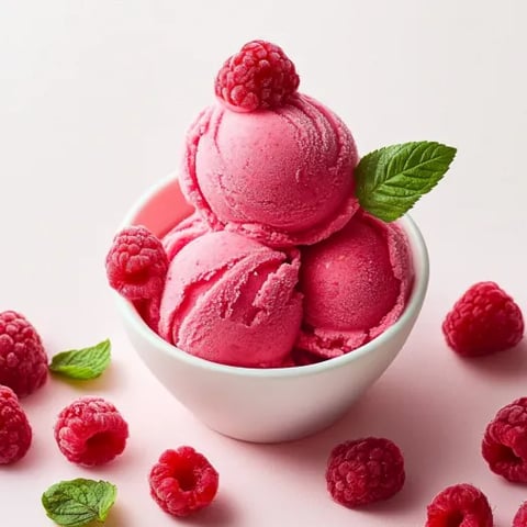 A bowl of pink raspberry ice cream.