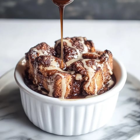 A dish of golden bread pudding with a spoon.