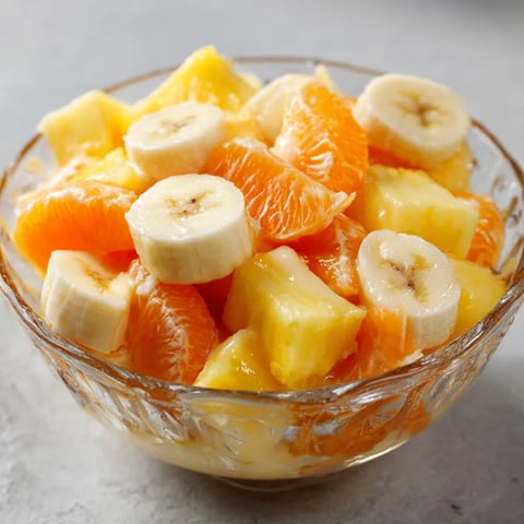 A bowl of fruit with bananas and oranges.